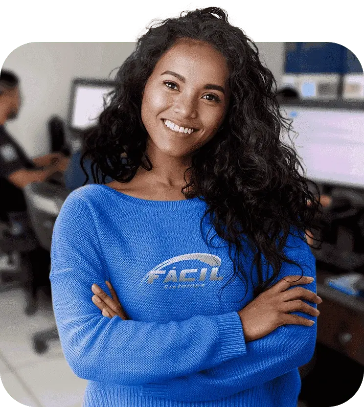 Atendente da equipe de suporte da Fácil Sistemas, com a central de atendimento ao fundo